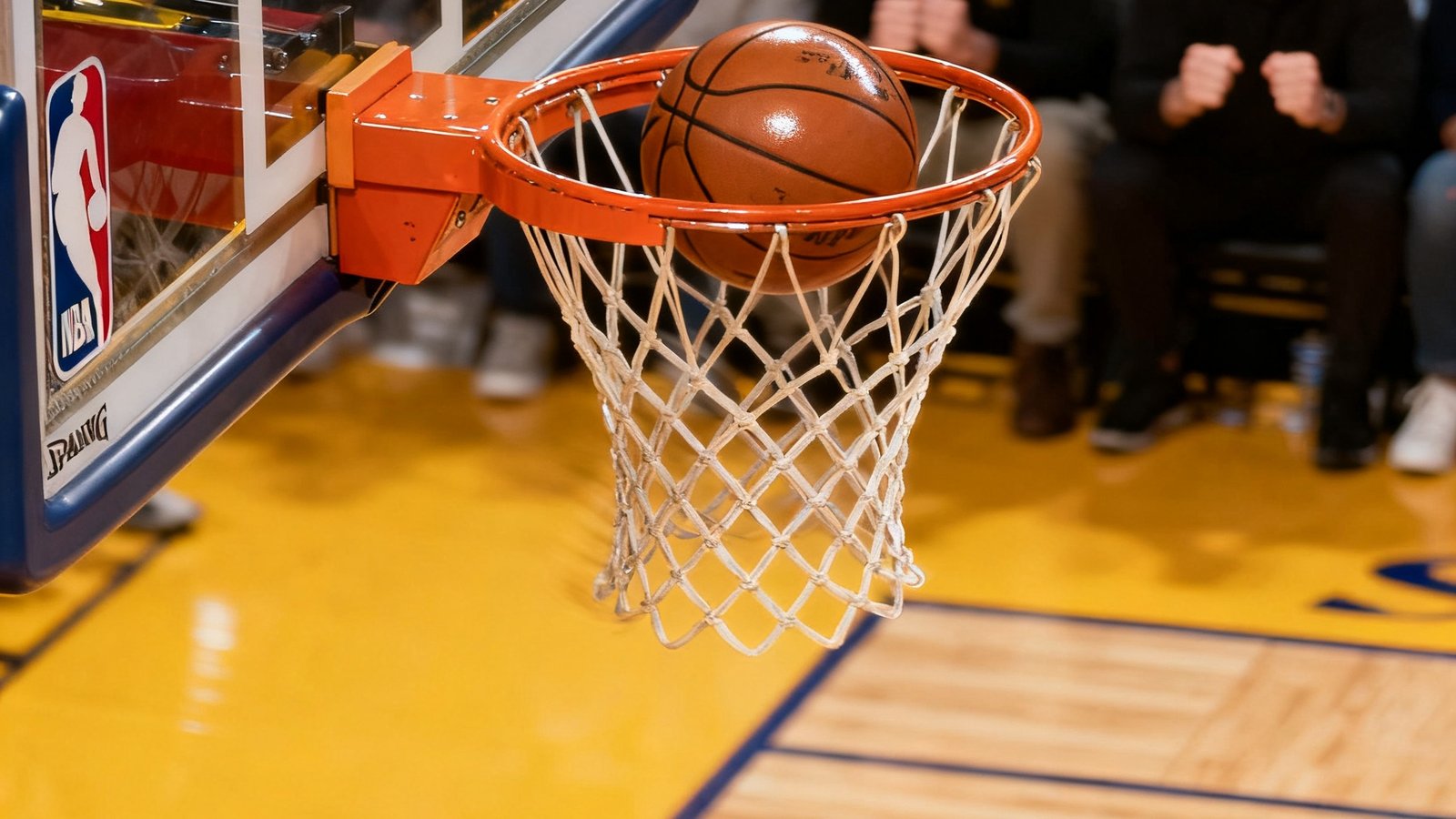 NBA球场地板特写视角，篮球在篮筐边沿旋转的瞬间定格，背景虚化中可见观众屏息凝神的表情